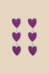 Amore oorbellen met drie sierlijke paarse hartjes op een rij